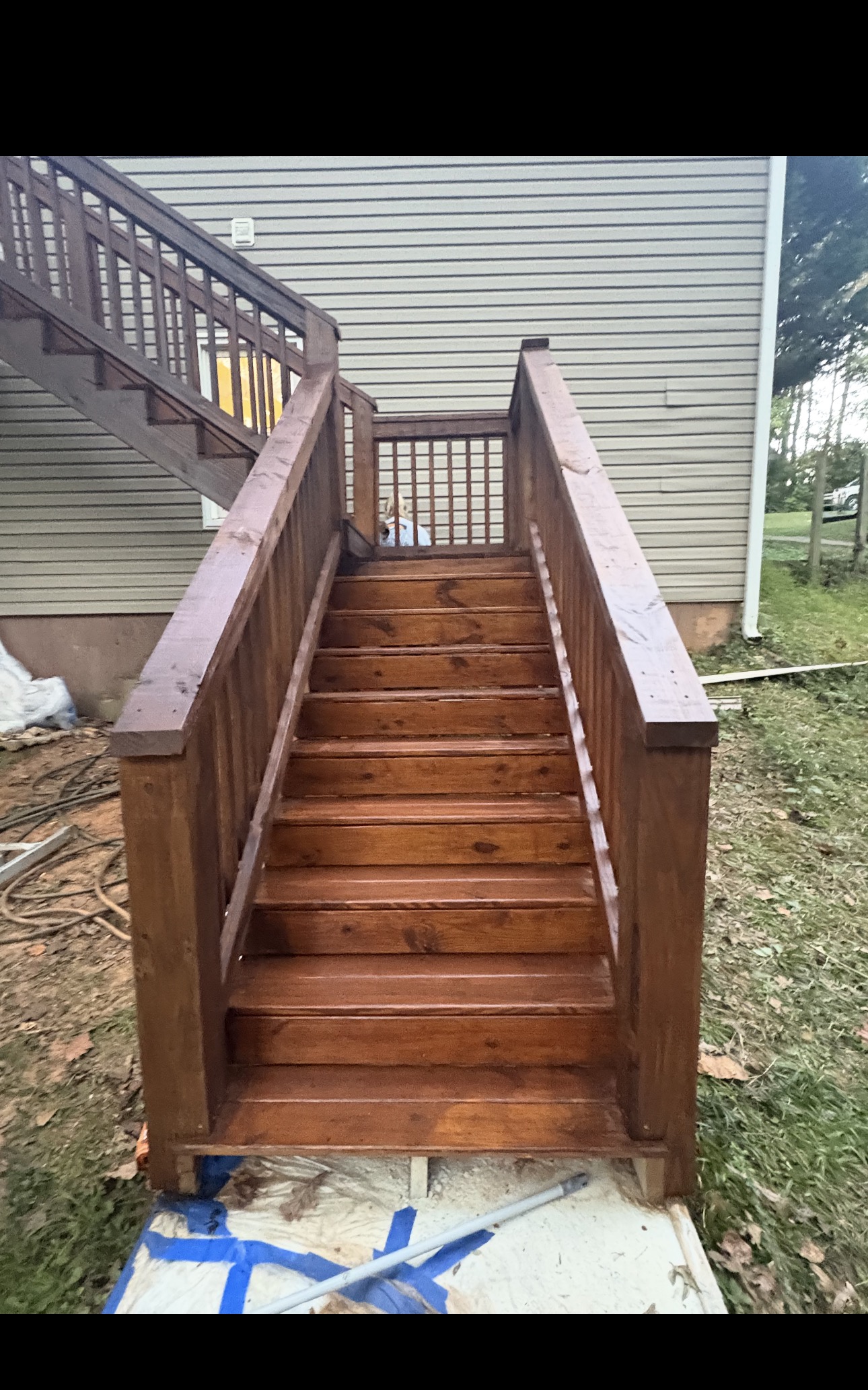 Freshly stained dark-walnut wood staircase against a Southern home