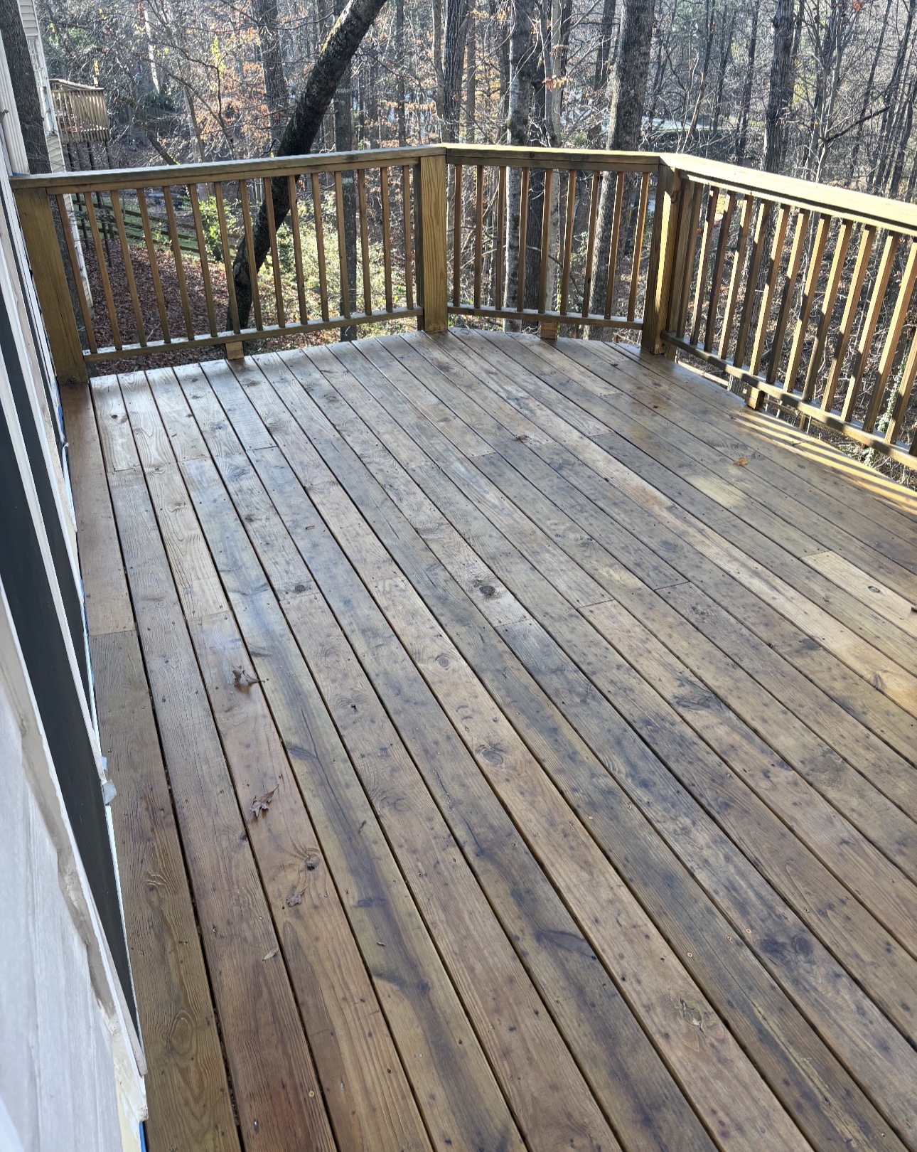 Long stained deck overlooking wooded backyard